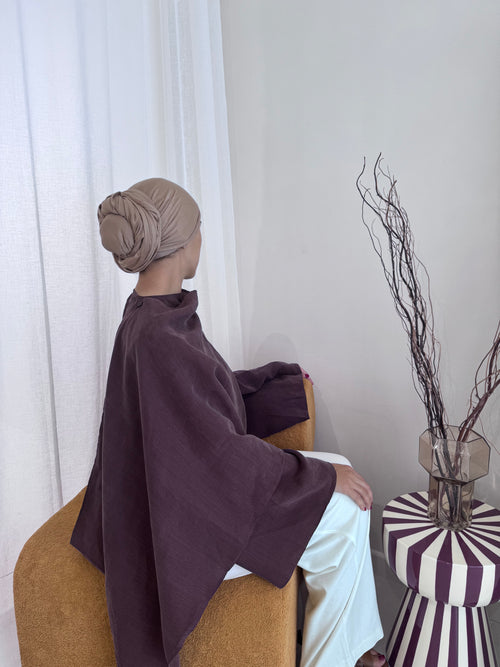 L’Envol aubergine portée assise, tunique asymétrique à cape pour femme voilée