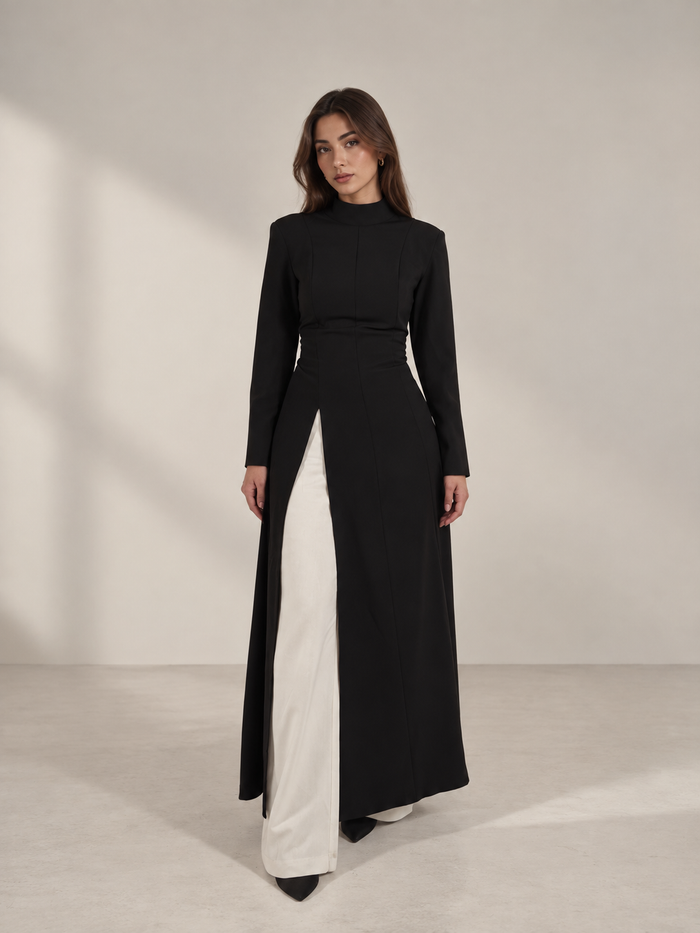 Tunique longue noire L’Aurore portée sur un pantalon blanc, mode modeste femme
